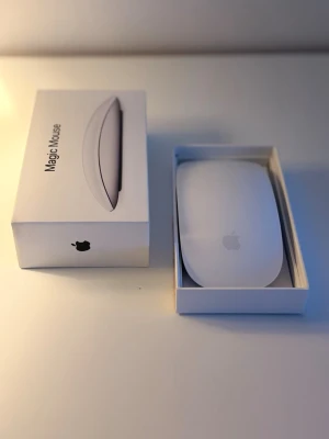 Apple Magic Mouse vit - Säljer en Apple Magic Mouse i vit färg. Musen har en slimmad och modern design med rundade kanter och glasliknande yta. Perfekt för dig som vill ha en stilren och trådlös mus till din dator. Levereras i originalförpackning.