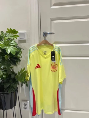 Gul Spanien matchtröja Adidas - Perfekt för alla Spanien-fans inför VM 2026! 🏆🇪🇸  ✅ Helt ny med tags ✅ Storlek M ✅ Adidas-design ✅ Skickas samma dag 📦 ✅ Endast 399 kr  Snygg och unik färg som sticker ut både på läktaren och till vardags. Först till kvarn! 🚀   Spanien, Spanien tröja, Spanien fotbollströja, Spanien jersey, Adidas, fotbollströja, landslagströja, VM 2026, FIFA World Cup 2026, Spanien landslag, La Roja, sportkläder, football shirt, soccer jersey, supportertröja, Adidas football 