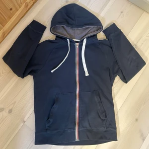 ZIP-HOODIE | PIER ONE. - Snygg mörkblå hoodie med dragkedja i regnbågsfärger och vita snören. Hoodien har en stor huva, två framfickor och mjukt grått innerfoder i huvan. Perfekt för en avslappnad och cool stil.