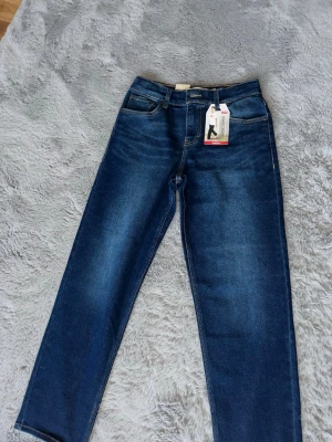 Mörkblå Levi's 511 slim jeans - Säljer ett par mörkblå Levi's 511 slim jeans med klassisk femficksdesign och snygga kontrastsömmar. Jeansen har normal midja, raka ben och är tillverkade i stretchig denim för extra komfort. Perfekta för en avslappnad och trendig look.