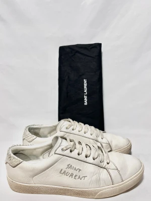 Saint Laurent Sneakers  - Saint Laurent skor i en unik vit modell! Fint skick, inga tydliga defekter. Storlek 40. Dustbag ingår. Kontakta mig för fler frågor och funderingar!