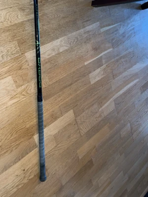 Innebandyklubba från Oxdog - Säljer en innebandyklubba från Oxdog med svart skaft och gröna detaljer. Greppet är lindat med grått greppband och bladet är lila. Perfekt för dig som gillar innebandy och vill ha en snygg och funktionell klubba.