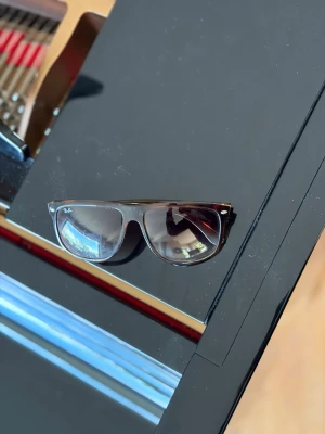 Ray-Ban svarta solglasögon Wayfarer - Klassiska svarta Ray-Ban Wayfarer solglasögon med mörka glas och ikonisk form. Snygg och tidlös design med Ray-Ban-logga på linsen. Perfekta för dig som vill ha en cool och stilren look i sommar.