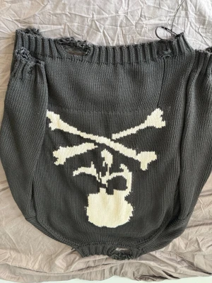 Stickad tröja - Svart stickad tröja med dödskalle på ryggen. Den e stickad i ett jätte skönt material och e ganska tjock o varm. Designen på tröjan är att den har hål i slutet av ärmar och midja så som man ser på bilderna. Köpt för 1 halvårssen för 2500 men användit den endast 2 gångar sedan dess