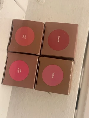 Rhode Pocket Blush i fyra nyanser - Fyra Rhode Pocket Blush i nyanserna Juice Box (klarrosa), Piggy (ljusrosa), Tan Line (varm beige) och Freckle (dov terrakotta). Kommer i stilrena bruna förpackningar med färgmarkering på locket. Perfekt för att skapa olika looks och addera färg till kinderna.