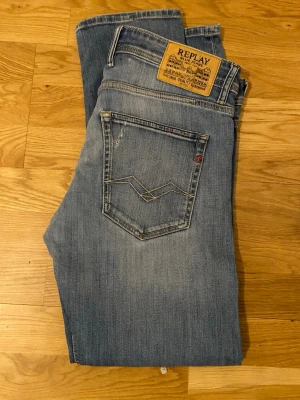 Blå raka jeans från Replay - Snygga blå jeans från Replay med klassisk femficksmodell och raka ben. Jeansen har en ljus tvätt och detaljerade sömmar på bakfickan. Tillverkade i mjukt denimtyg som ger en avslappnad look.