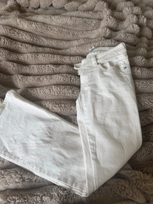 Vita bootcut jeans från 157 - Säljer ett par vita jeans från 157 med klassisk femficksmodell och raka ben. Jeansen har normal midja och är tillverkade i ett mjukt denimtyg. Perfekta för dig som vill ha en clean och fräsch look till vardags.