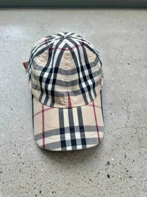 Äkta burberry keps  - Äkta burberry keps, med det klassiska mönstret. One size men har även två reglage som visas på bild 4. Skicken är mellan mycket bra och bra! Säljer för ett bra pris. Passar unisex 