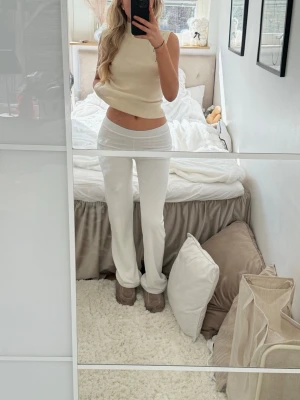 Vita raka kostymbyxor - Säljer ett par vita kostymbyxor med rak passform och medel/låg midja. Byxorna har en stilren look utan synliga fickor eller detaljer och är perfekta för en clean och modern stil. Materialet ser ut att vara mjukt och följsamt, vilket ger en snygg siluett. Passar även folk i S som mig. Säljer för att de inte kommer till användning 💗