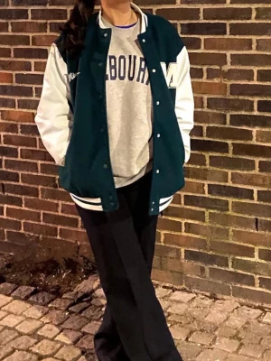 Grön och vit collegejacka från H&M med detaljer   - Cool grön och vit collegejacka med stora vita ärmar och detaljer. Jackan har tryckknappar framtill och en stor M-detalj på bröstet. Från H&M, bra skick köptes för cirka 4 år sedan och använd några få gånger. Nypris 499kr, är 158 lång och har denna i M för den ska vara oversized och denna passade perfekt! 