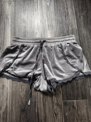 Mjukisshorts - Mjukisshorts i mjukt velourmaterial med spetskanter och snören. Köptes begagnad och har använts en del men fortfarande i bra skick.