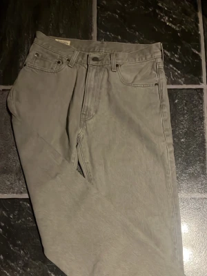 Gråa Levi's Premium jeans - Snygga gråa jeans från Levi's Premium med klassisk femficksmodell och raka ben. Jeansen har en stilren look och är tillverkade i slitstarkt denimtyg. Perfekta för dig som gillar en clean och tidlös stil.   100 cm  från lägsta punkt till högsta punkt