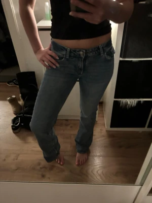 Ljusblå raka jeans med låg midja - Säljer ett par ljusblå jeans med rak passform och låg midja. Jeansen har klassiska fem fickor och stängs med dragkedja och knapp. Perfekta till en avslappnad look och passar till det mesta. Materialet är denim i bomull.