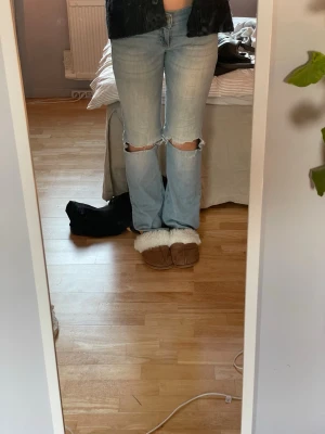 Ljusblå jeans med hål - Säljer ett par ljusblå jeans med slitna hål över knäna. byxorna är i storlek S men har töjts ut runt lår och knä. eftersom att slutet på jeansen är slitna så sänker jag priset!!❣️❣️