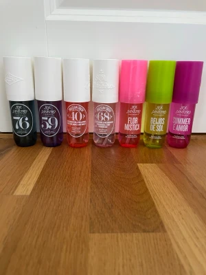 Sol de Janeiro parfymkollektion - Säljer en samling Sol de Janeiro parfymer i olika färgglada flaskor med vita, rosa, gröna och lila lock. Kollektionen innehåller flera dofter som 76, 59, 40, 68, Flor Mistica, Beijos de Sol och Summer e Amor. Flaskorna är av plast och glas, och har en modern, ungdomlig design. 7 bodymists, 2 duschgels samt en parfym.