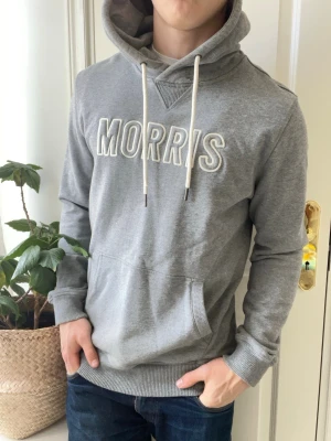 Morris hoodie grå  - Morris hoodie grå, Inga defekter förutom två fläckar som sitter under luvan, syns inte särkilt mycket pga luvan! Modellen i bilderna är 180 cm 75 kg och bär Storlek L , Kom med frågor! 🌟 (Kan gå ned i pris vid köp av paket 😉) 
