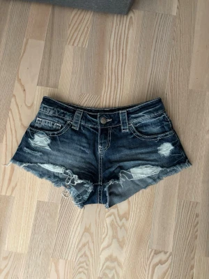 Mörkblå jeansshorts - Säljer ett par snygga mörkblå jeansshorts med slitna detaljer och fransig kant. 💙