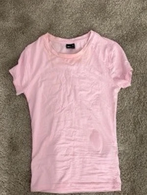 Ljusrosa basic t-shirt från Gina tricot - En enkel och mjuk ljusrosa t-shirt. Modellen är klassisk med rund halsringning och korta ärmar. Tillverkad i bomull.