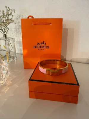 Herme’s-inspirerat guldarmband med rosa detaljer 💕 - Hej tjejer 💕 Säljer detta Herme’s inspirerat-armband i guld med rosa detaljer. Superfint och ger en lyxig touch till alla outfits. I väldigt fint skick och sparsamt använt. Hör av er vid intresse eller frågor ✨