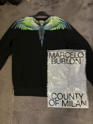 Marcelo Burlon Crewneck  - Säljer nu min schyssta Marcelo Burlon crewneck! Riktigt unik tröja för dig som älskar att sticka ut med mycket fina färger. Tröjan är i mycket bra skick och är inte använd mycket alls. Säljer den pga att den är lite för stor för mig. Produkten är köpt för 4299kr på deras egna hemsida. Priset går att diskutera! Varan är 100% äkta och inte samma som den skiten folk säljer på plick ( därav mycket bilder som tyder på äkthet) 