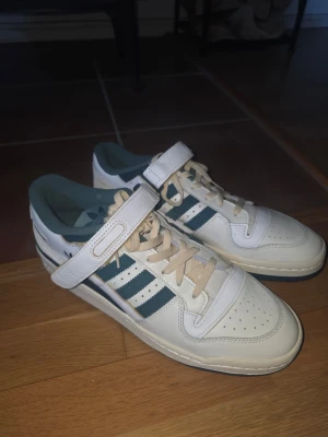 Adidas Forum Low - De är gröna/ vita/ krämfärgade skor. De är aldrig använda men de har lite defekter (ser ut som vit färg eller lim på gröna delen se bild 1 och 2). Har tyvärr inte kvar orginal lådan.