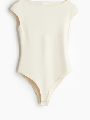 Krämvit enkel body med kort ärm - Säljer en stilren krämvit body med korta ärmar och rund hals. Bodyn har en slät, mjuk yta och knäppning i grenen. . Materialet känns stretchigt och bekvämt.❣️