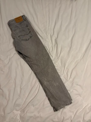 Gråa Jack&Jones jeans  - Ett fina par Jack& Jones som är använda och är för små nu och det har gått lite sönder där vid hälen. Men annars är det sköna och bekväma. Storlek; W32L31