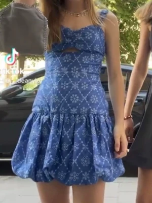 Zara klänning  - Supersöt blå kort klänning med vitt blommönster och ballongkjol. Klänningen har breda axelband, en liten cut-out vid bysten och markerad midja. Perfekt för sommarens alla tillfällen!