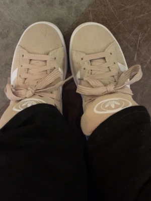Beige Adidas Campus sneakers - Säljer ett par beige Adidas Campus sneakers i mocka med klassiska vita ränder, skorna är helt nya och fräscha, använda 1 gång, säljer då jag hittat andra skor jag vill ha 🥰 pris går att diskutera