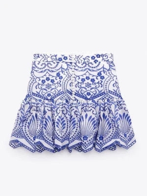 Vit och blå mönstrad kjol med volang - Supersnygg kjol i vitt och blått med broderat mönster och dekorativa knappar framtill. Kjolen har volang nertill och markerad midja. Från Zara