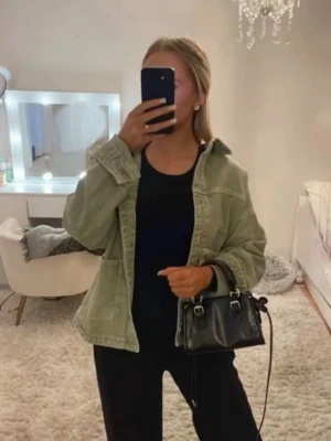 Grå jeansjacka från Zara - Säljer en oversized grå jeansjacka från Zara med klassisk krage och stora frontfickor. Jackan har knappar hela vägen och är tillverkad i denim. Perfekt för att skapa en cool och avslappnad look.