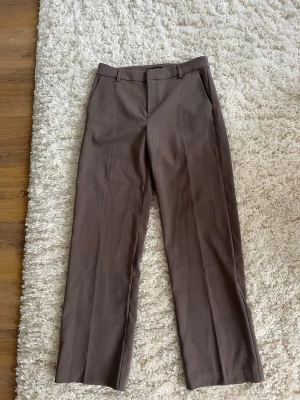 Bruna raka kostymbyxor - Snygga bruna kostymbyxor med raka ben och pressveck. Aldrig använda bara testade, lappen är kvar. 