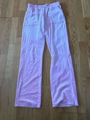 Ljusrosa mjukisbyxor från Juicy Couture  - Säljer ett par ljusrosa mjukisbyxor från Juicy Couture i storlek 12/13 år
