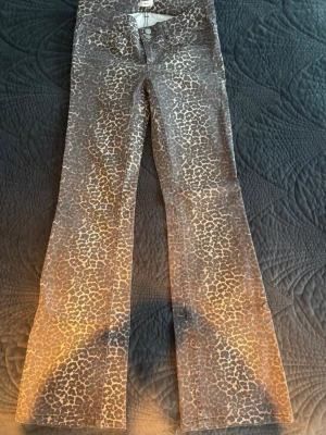 Leopardmönstrade bootcut jeans - Säljer ett par snygga leopardmönstrade jeans med bootcut-modell. Jeansen har  normalhög midja och är i ett stretchigt bomullsmaterial. Perfekta för dig som vill sticka ut med ett djurmönster! Använda 1 gång 