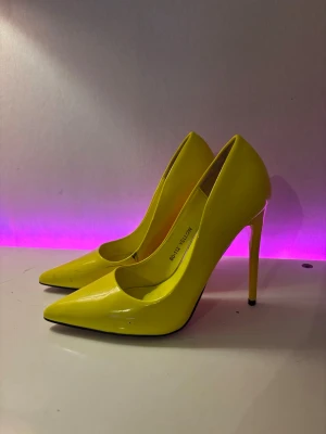 Gula lackpumps med spetsig tå - Snygga gula pumps med hög smal klack och spetsig tå. Skorna är i glansigt lackmaterial och har en klassisk siluett som sticker ut. Köpta från asos 899kr för ca 4år sedan, använt fåtal ggr men skada syns på bild därav priset.