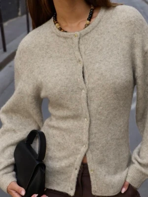 Beige kofta i ullblandning - Beige kofta med rund halsringning och knäppning framtill. Helt ny! 