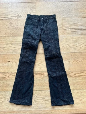 Manchesterbyxor från Levis - Svarta manchesterbyxor med diskret blommigt mönster. Byxorna är flare modell. Skulle säga att de passar strl. 36-38