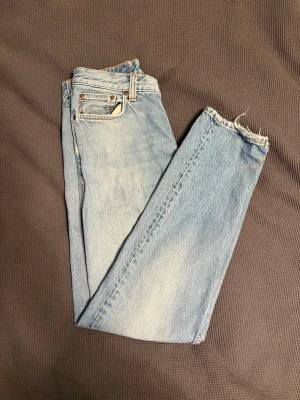 Jeans från Nudie - Säljer ett par ljusblå raka jeans från Nudie. Jeansen har en snygg tvättad look och Nudie-loggan på bakfickan. Perfekta för en avslappnad och trendig stil. Storlek: W:28, L:30