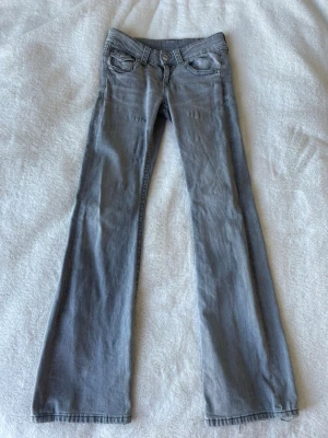 Ljusgrå bootcut jeans - Säljer ett par ljusgrå low waist jeans med bootcut-modell och klassiska fem fickor. 