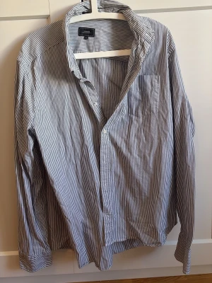 Randig skjorta från Boomerang  - Säljer en klassisk blåvit randig skjorta från Boomerang i storlek XL. Skjortan har en bröstficka, knappar framtill och lång ärm.     Märke• Boomerang                                             Köpt för• ca 500kr                                           Mitt pris• 190kr