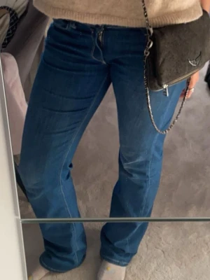 Lågmidjade bootcut jeans från Replay - Säljer ett par blå bootcut jeans från Replay låg midja. Jeansen har en snygg tvätt och är tillverkade i mjukt denimtyg som sitter skönt. SUPER snygga och sitter så bra men de passar inte mig längre. Waist 29 & length 34. Använda men i ett väldigt bra skick❣️