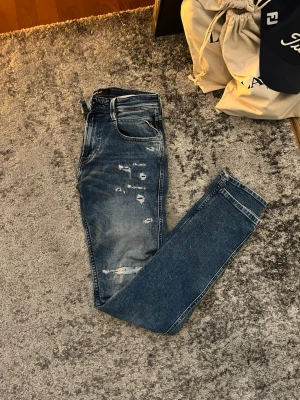 Replay jeans  - Säljer nu dessa blå Replay jeans med slitningar och hål på framsidan. Jeansen har raka ben, klassisk femficksmodell och en tvättad look, perfekt nu till våren och sommarn. Nypris :1400 kr, Mitt pris: 400 kr