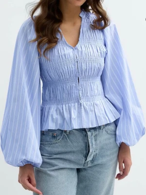 Blå smockblus med ballongärmar - Supersöt blå smockblus som trendar mycket nu. Tröjan är i nytt skick och har aldrig använts därav finns prislapp kvar. Passar verkligen nu till vår/sommar. Köptes för 400kr