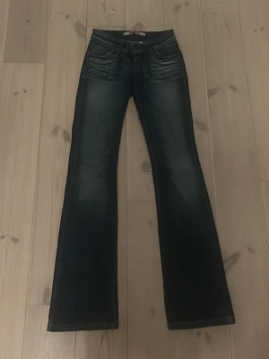 Gammal modell only jeans - Snygga mörkblå bootcut jeans  från only. Jeansen har fem fickor, låg midja och klassisk knappgylf. Materialet är denim med stretch för extra komfort. Det är en gammal modell så de finns inte att köpa längre!! Kan gå ner i pris vid snabbt köp de är ungefär 84 i innerbenslängd