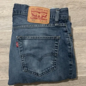 Levi's 511 blå jeans herr - Säljer ett par klassiska blå Levi's 511 jeans med smal passform och normal midja. Jeansen har fem fickor, dragkedjegylf och den ikoniska röda Levi's-lappen på bakfickan. Perfekta för en avslappnad och stilren look. W33 L32, (passar även för mindre storlekar) skickar samma dag vid köp🤩