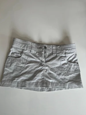 Vit/grå snygg minikjol - Supersnygg minikjol från Spy i storlek 8 - passar mig som har S superbra! Den är perfekt till sommaren och har ett väldigt skönt material