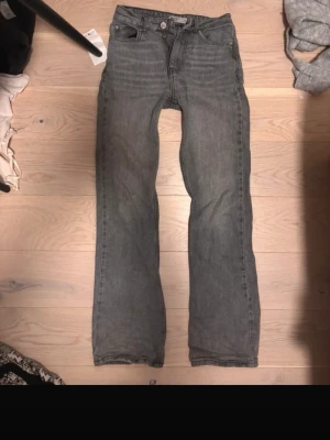 Grå raka jeans från Gina Tricot - Säljer ett par grå jeans från Gina Tricot med rak passform och klassisk femficksdesign. Jeansen har normal midja och dragkedja med knapp. Perfekta till en avslappnad stil och passar till det mesta. Materialet är denim i bomull. Inga skador som jag vet om 