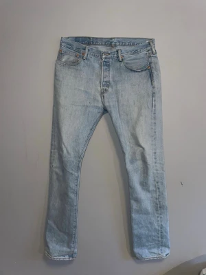 Vintage Levi's 501 - Säljer ett par klassiska ljusblå levis 501 jeans.. Jeansen är tillverkade någonstans på 90-talet därav ingen klassisk lapp i bak. Utöver det är skicket på topp, hör av er vid funderingar