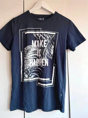 Mörkblå t-shirt med print från Solid. S - Mörkblå t-shirt med tryck. Storlek S. Från Solid . Köpt på herr avdelningen. Anvönd men i fint skick. Tryck helt o fint, lite ytludd. Fin. 
