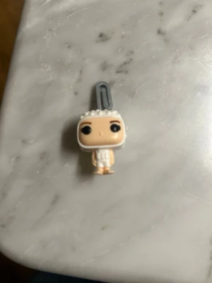 Stranger things funko pop. Eleven/Jane. - En rolig liten vit eleven funko pop kinder ägg figur. Den är gjord i plast och är mellan 3 och 4 cm.den sista bilden är en bild på förpakningen figuren ligger i när den fraktas. Förpackningen ligger såklart i ett större paket😊